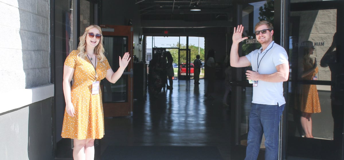 Two happy people shaking their hands at distance