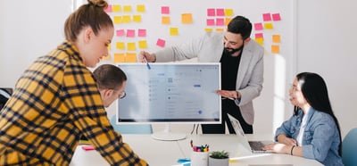 A person doing a presentation to a team of 2 people