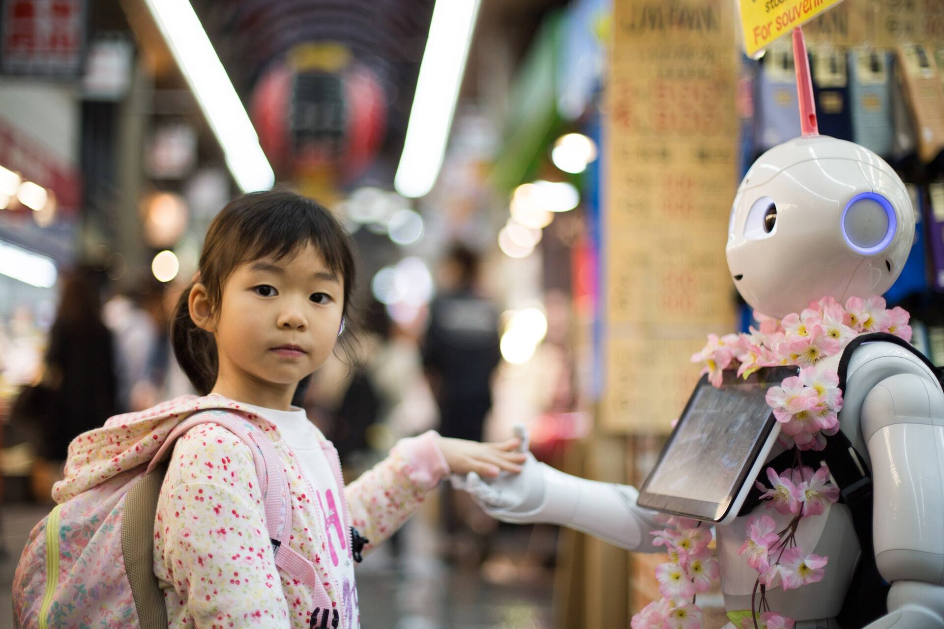 young girl shaking a robot hand