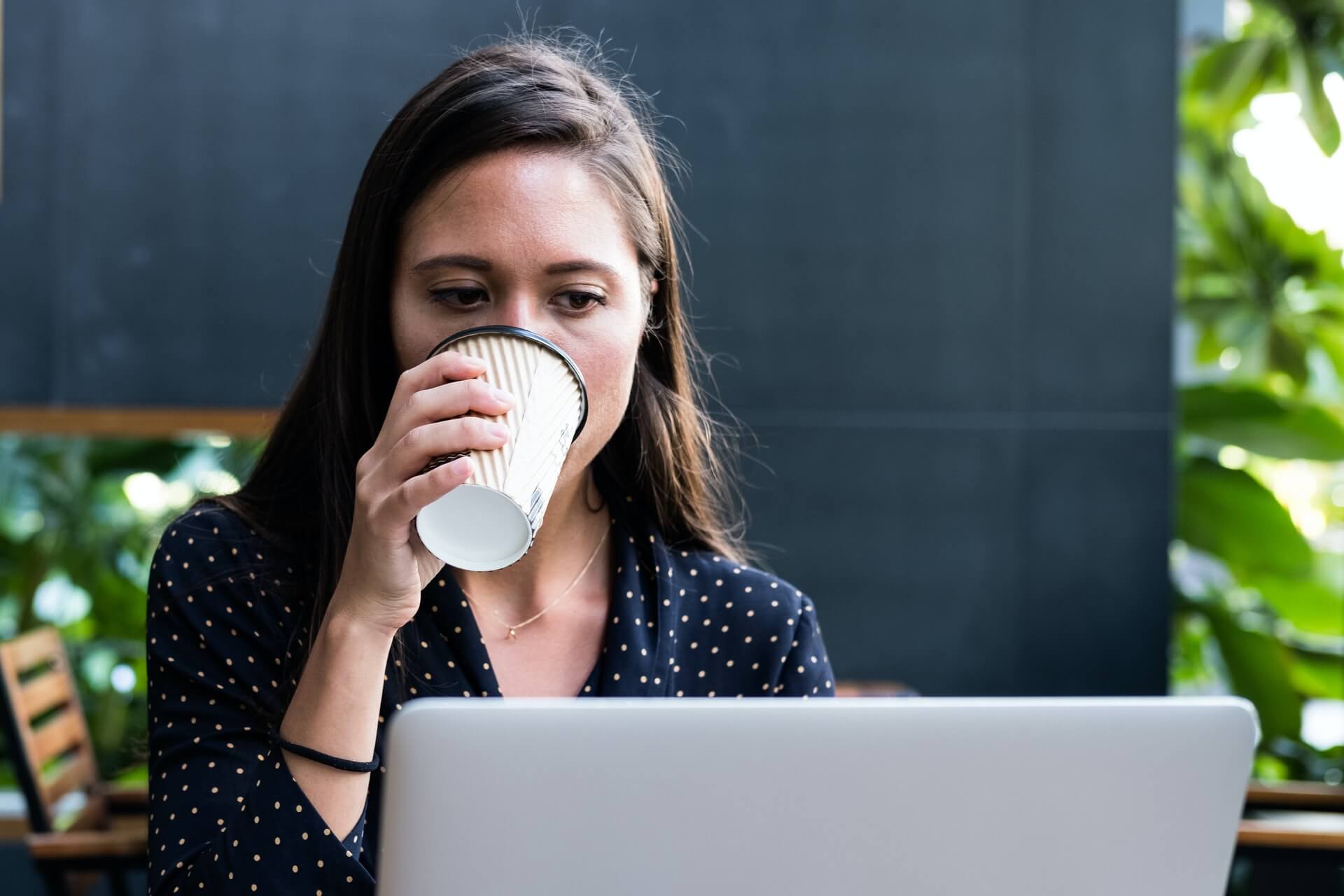 Woman drinking coffee and working at the same time