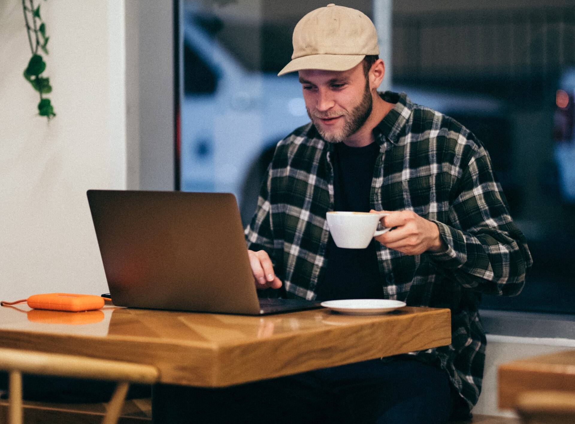 Man working in a computer and drinking coffee