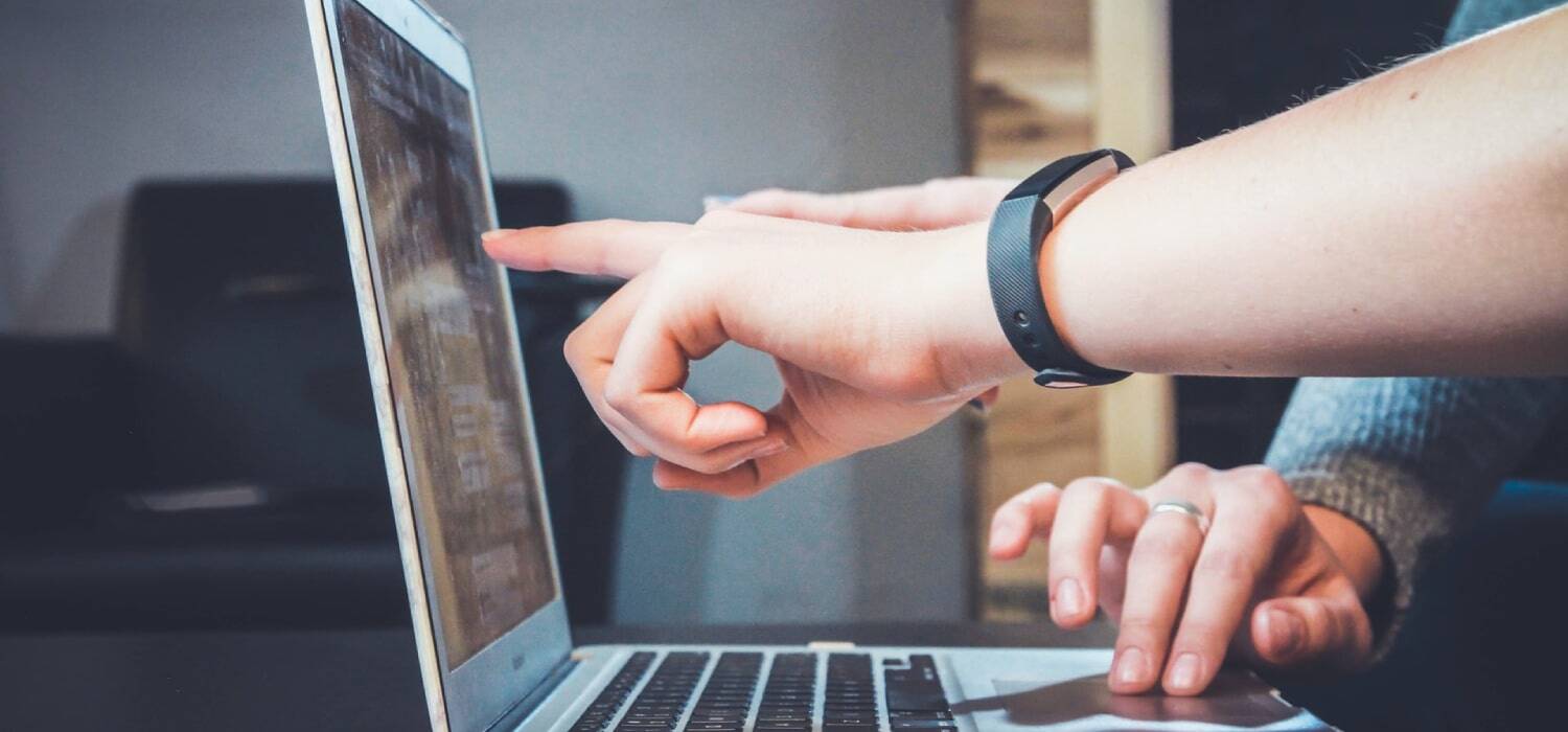 People pointing at a notebook screen