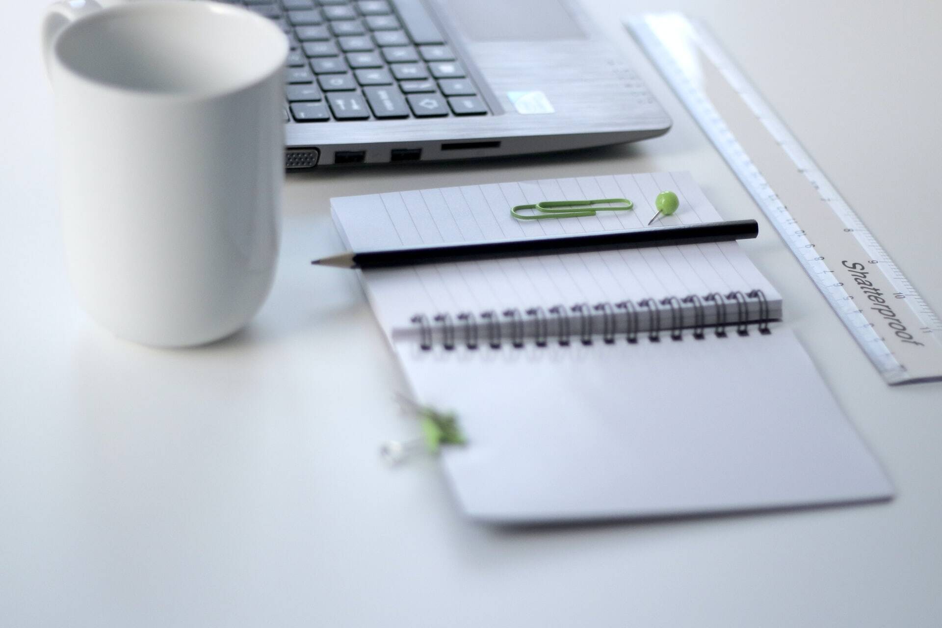 Notebook with a clip and pencil above