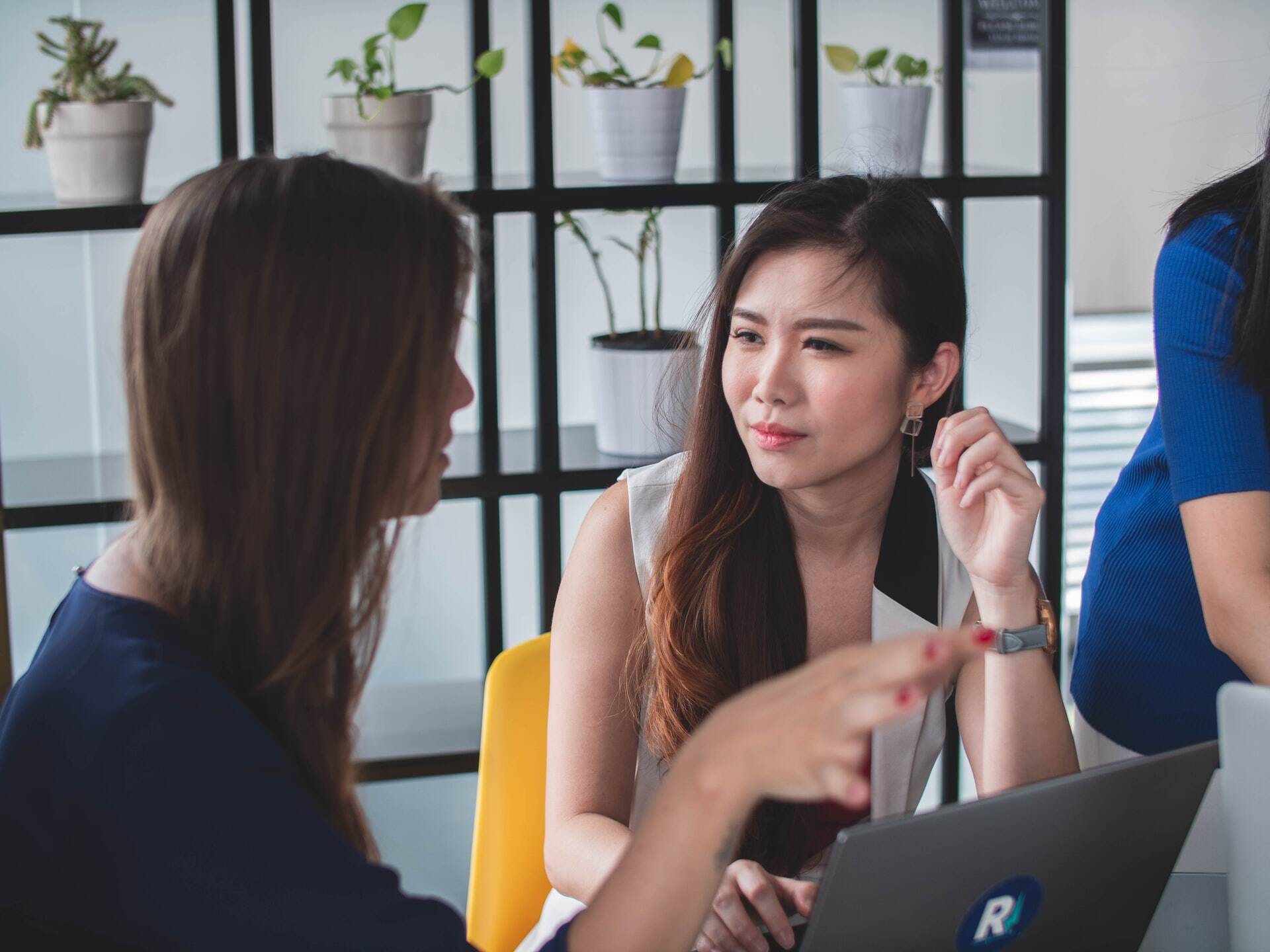 Two women talking in a meeting