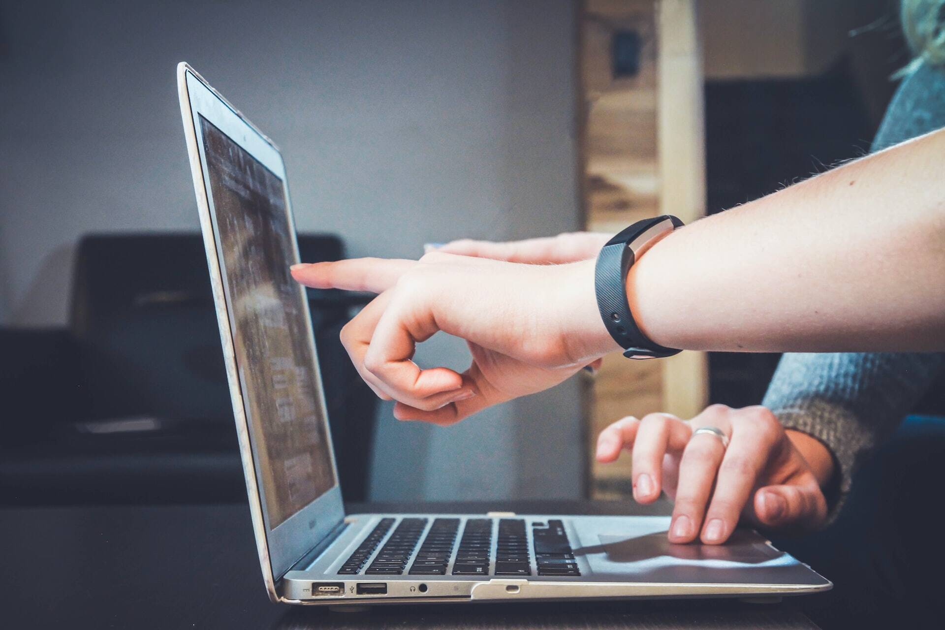 People pointing at a notebook screen