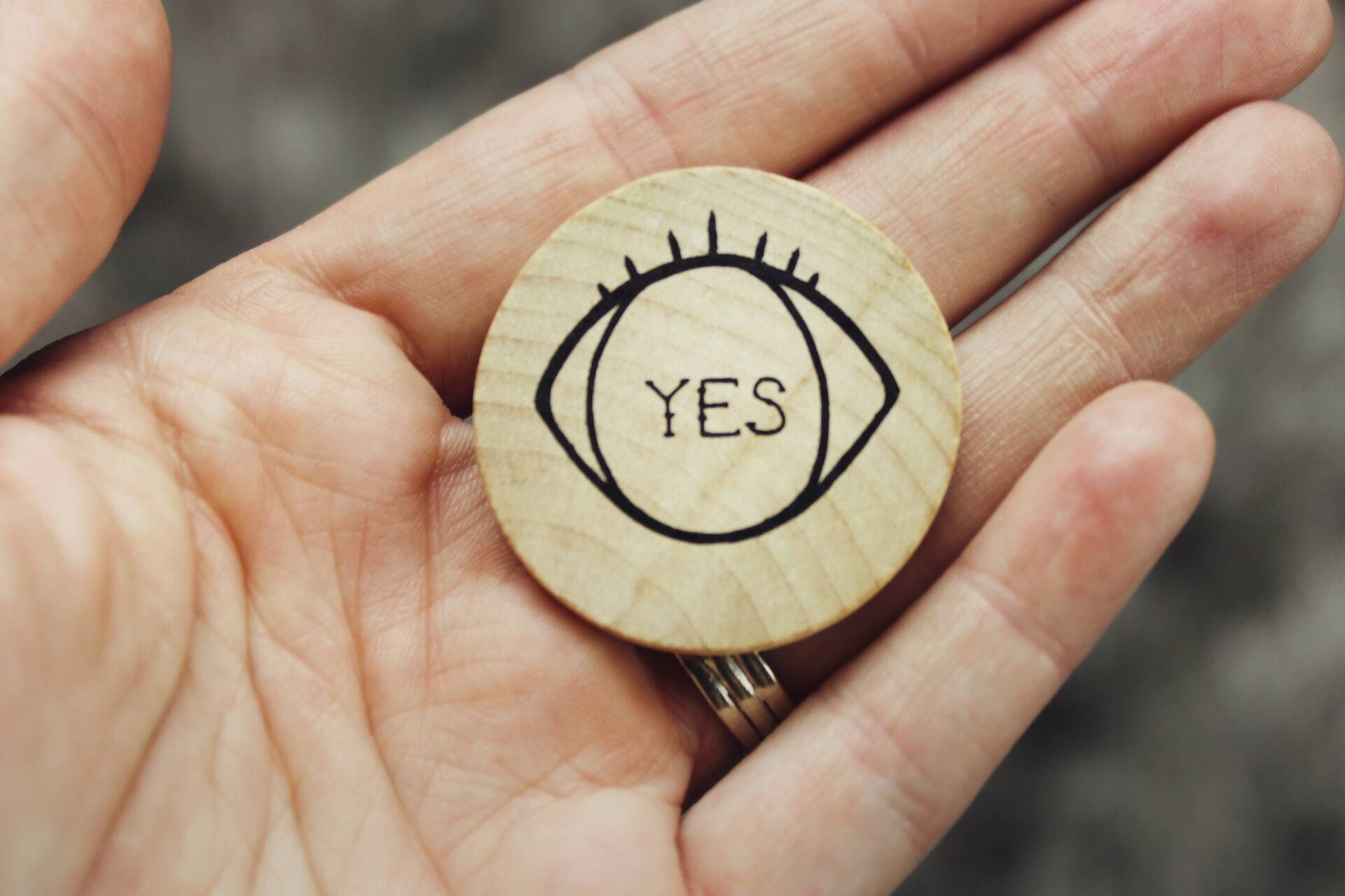 Yes written inside a eye drawing in a round piece of wood