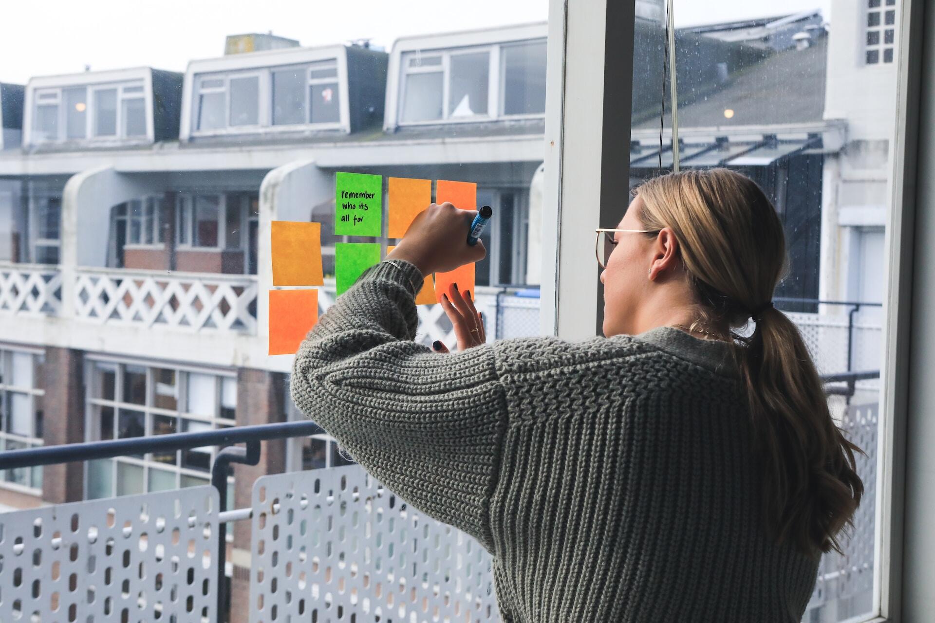 Woman writing notes in a post-it