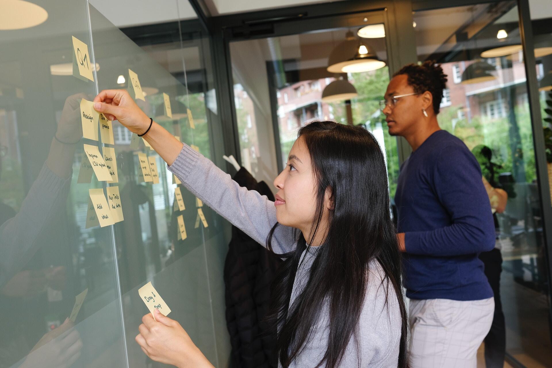 Two people organizing tasks in a board