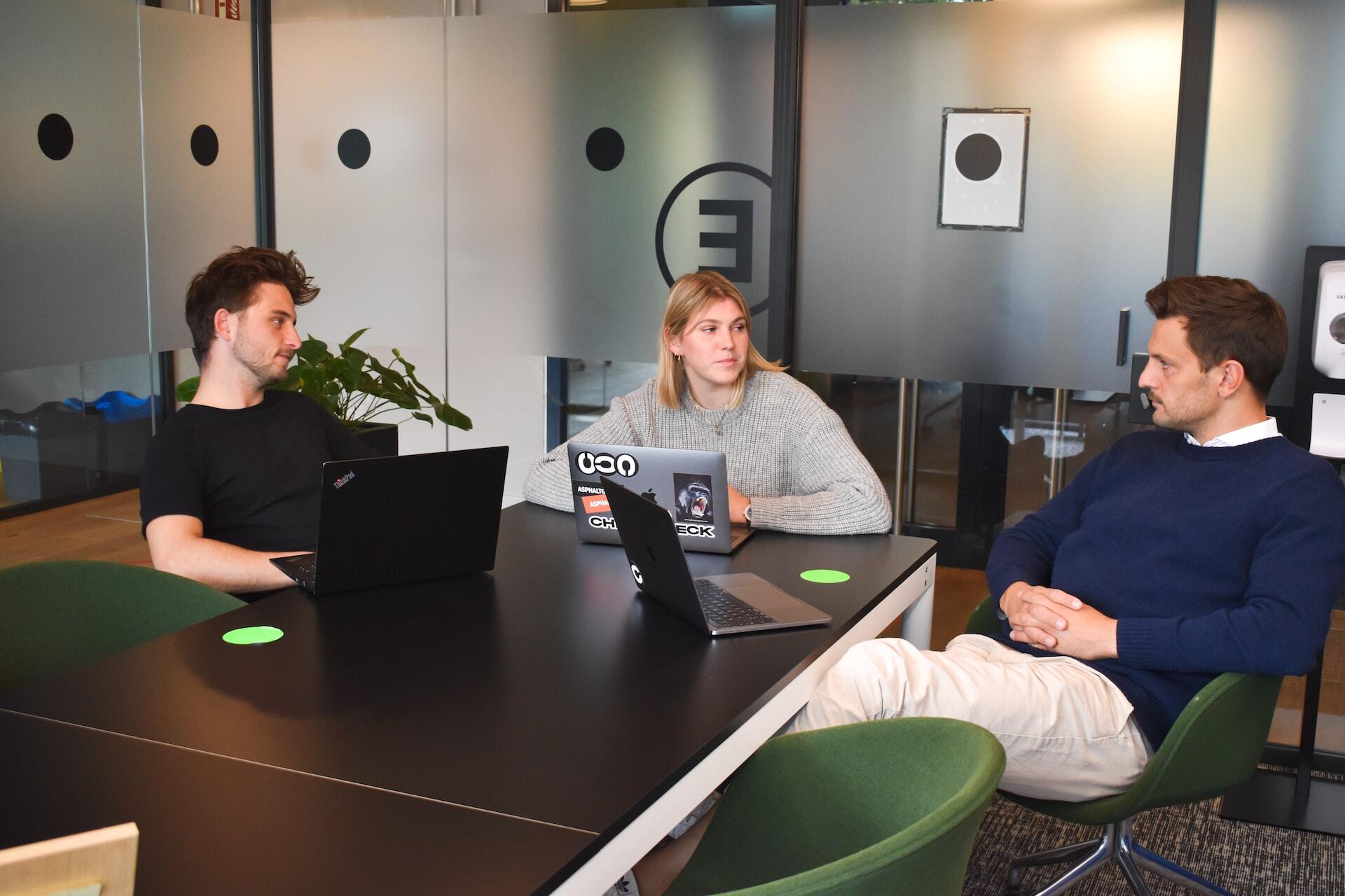 three serious people in a meeting