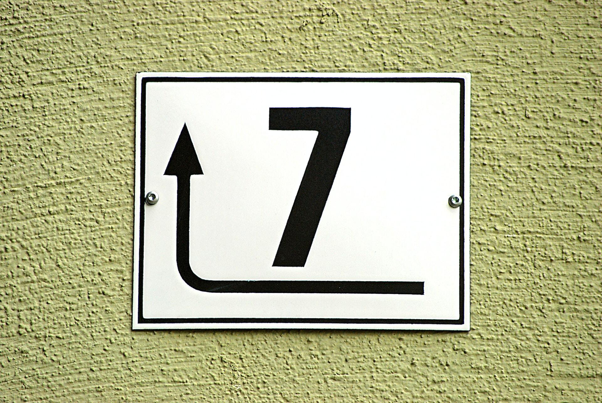 A sign with the number 7 and a arrow point forward