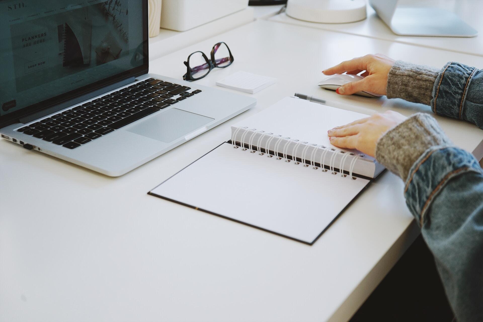 Woman using a paper agenda in front of a notebook