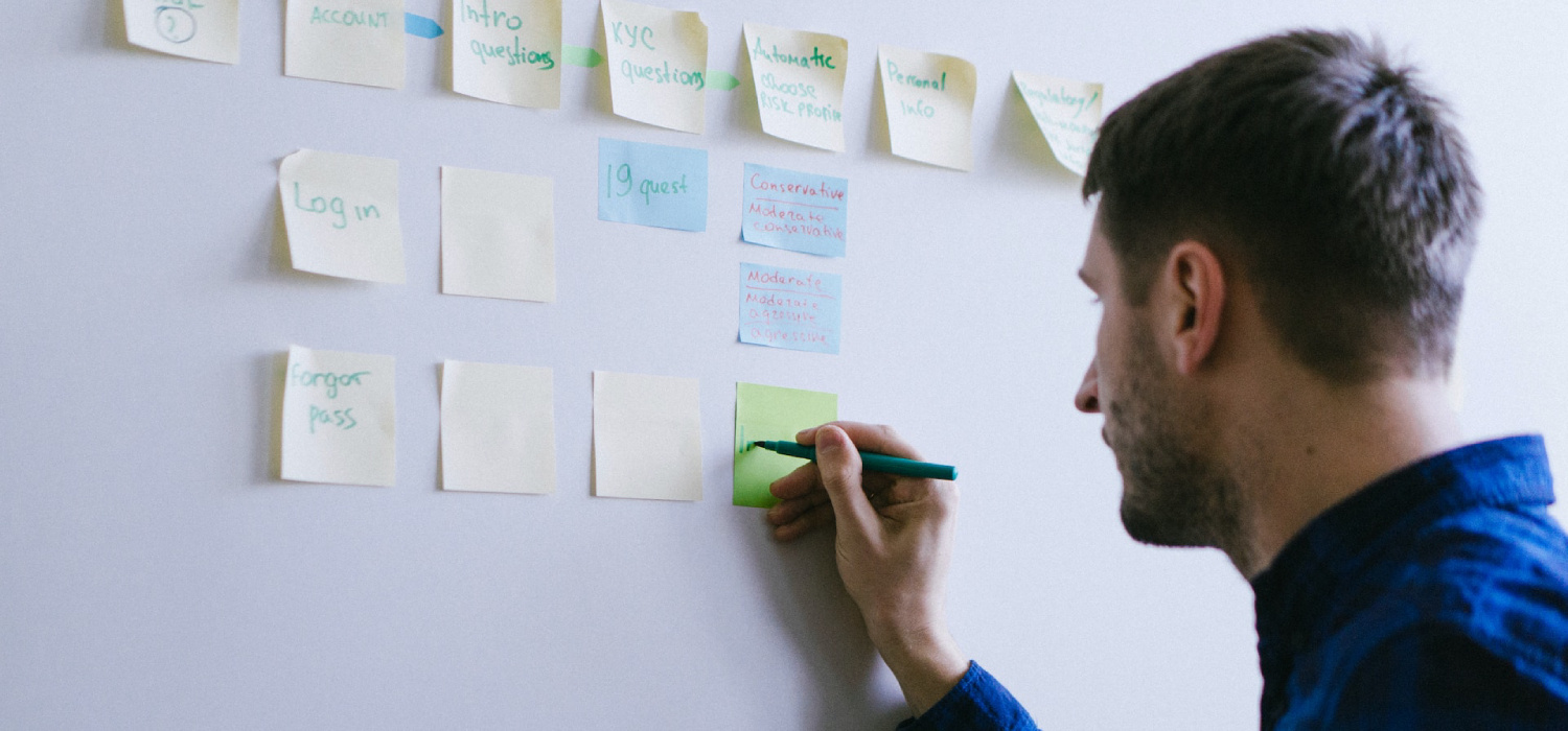 Person writing information in a post-it