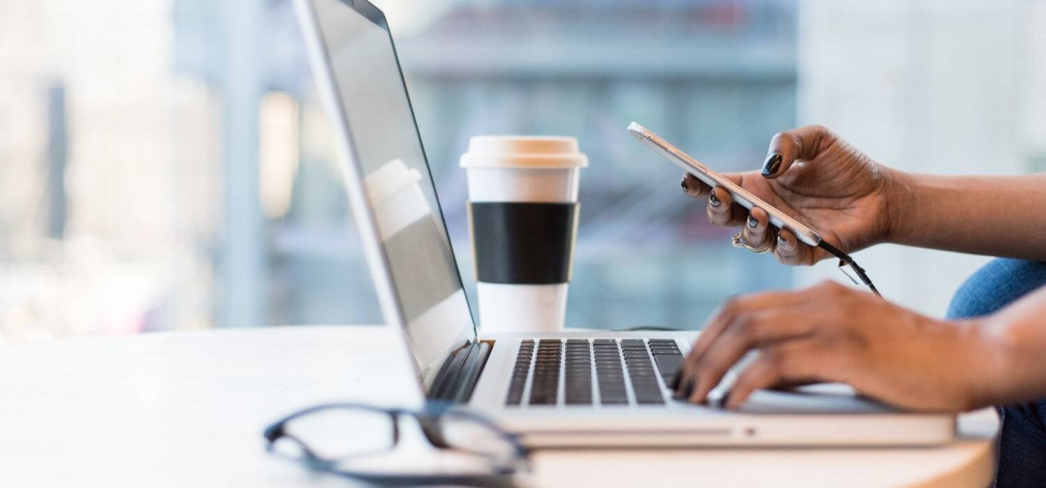 Person working in a computer right next to a coffee